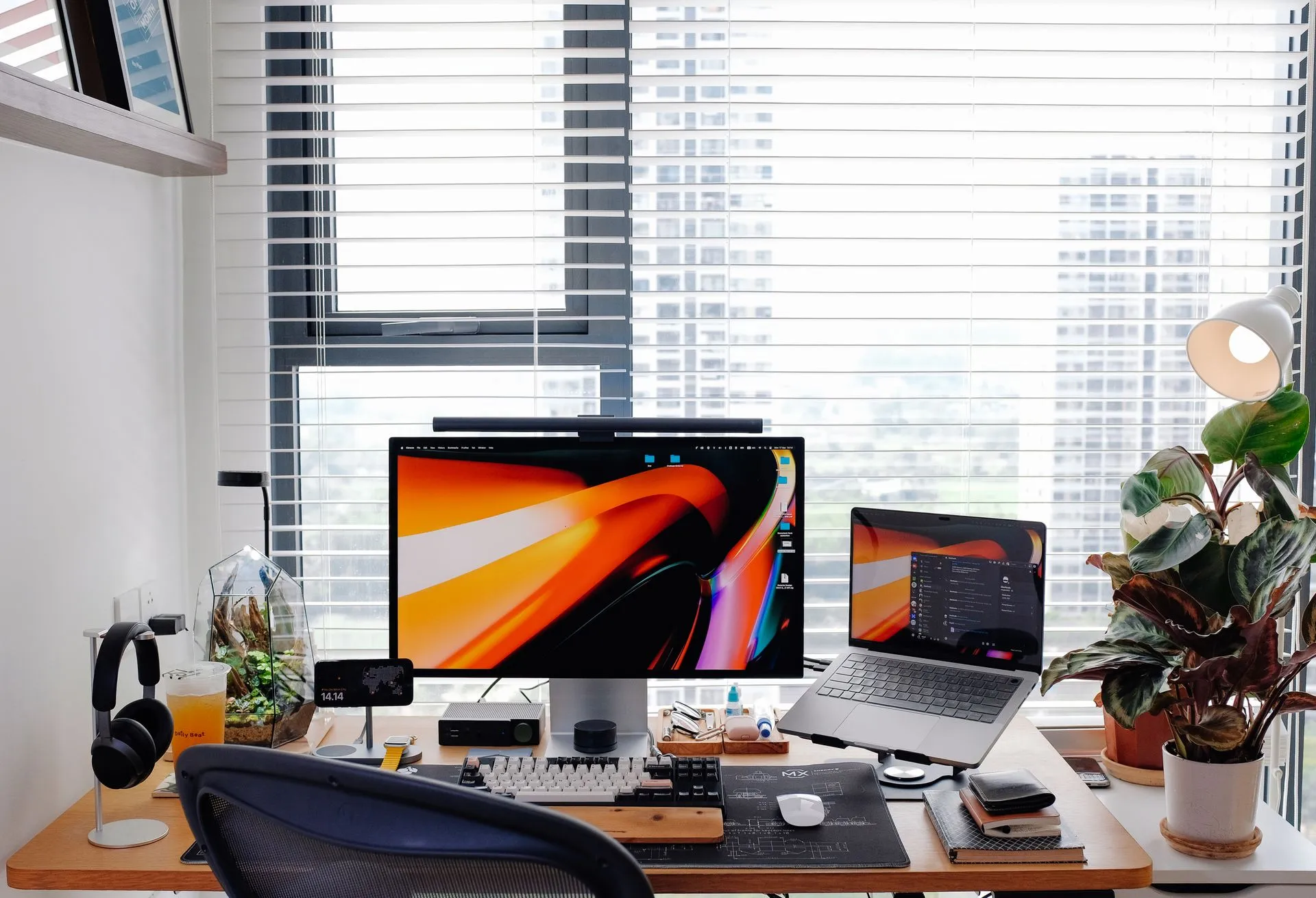 Modern desk workspace with dual monitors overlooking a city skyline